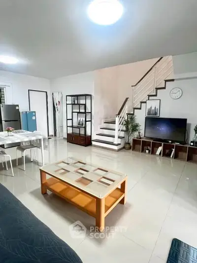 Spacious living room with modern decor and staircase in a stylish home
