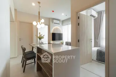 Modern open-plan living and dining area with stylish lighting and cozy bedroom view.