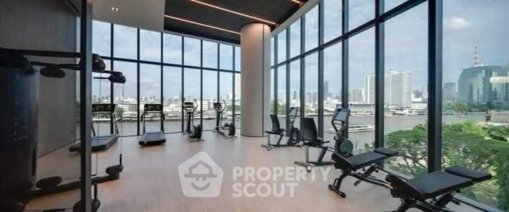Luxurious gym with panoramic city views and modern fitness equipment in high-rise building.