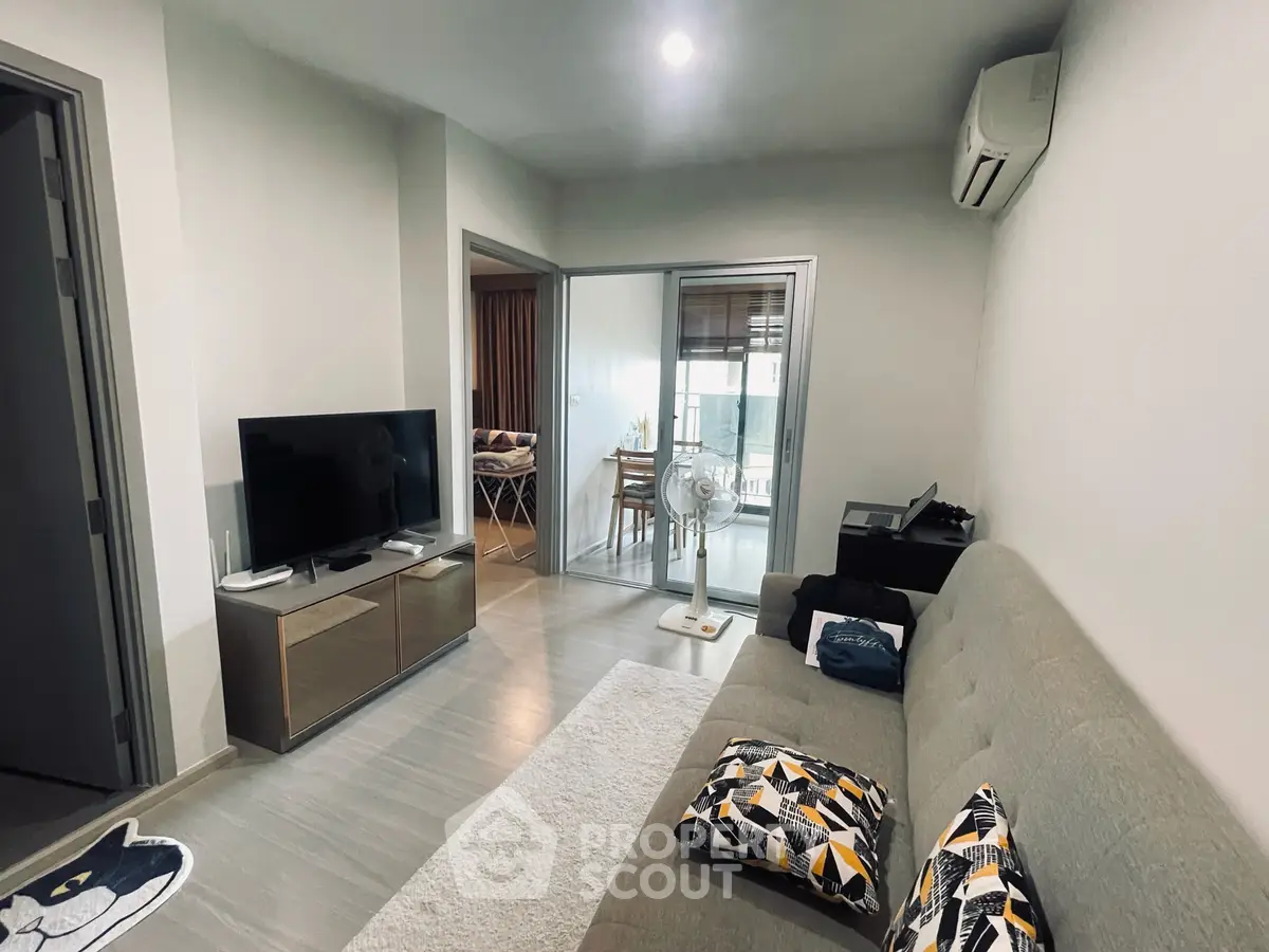 Modern living room with stylish decor and open layout, featuring a cozy sofa and sleek TV stand.