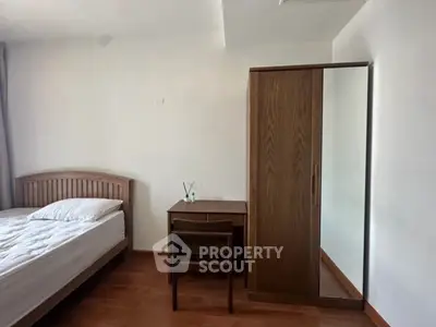 Cozy bedroom with wooden furniture and natural light, perfect for restful nights.