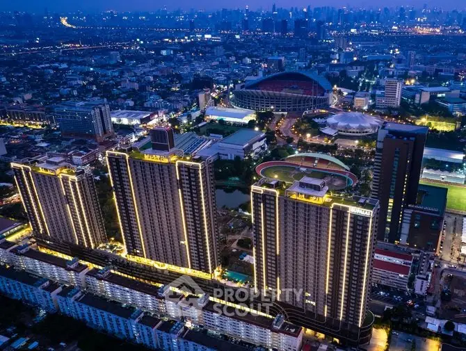 Stunning aerial view of illuminated high-rise buildings in a vibrant cityscape at dusk.