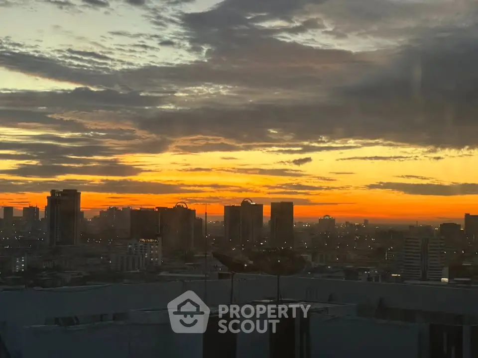 Stunning city skyline view at sunset with vibrant orange and yellow hues.