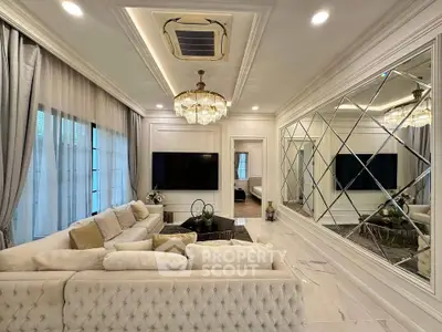Luxurious living room with elegant decor, plush seating, and mirrored wall for spacious feel.