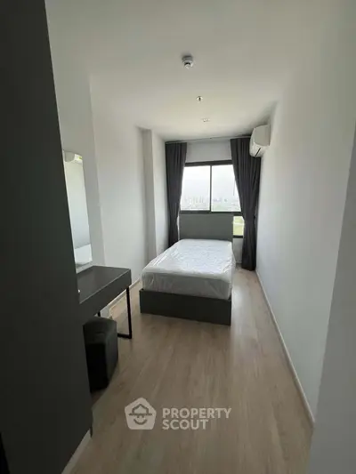 Modern minimalist bedroom with large window and sleek furnishings