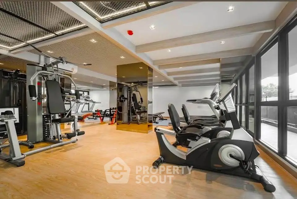 Modern gym with state-of-the-art fitness equipment and large windows for natural light.