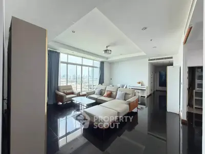 Spacious modern living room with large windows and city view, featuring sleek furniture and elegant design.