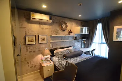 Cozy bedroom with modern decor and natural light, featuring stylish furniture and wall art.