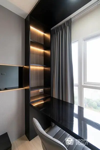 Modern study area with sleek black desk and built-in shelves near large window