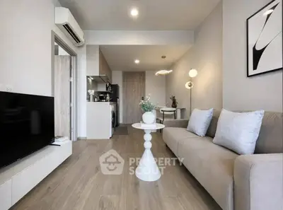 Modern living room with sleek furniture and open kitchen layout in a stylish apartment.