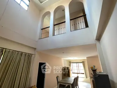 Spacious two-story living room with high ceilings and elegant arches.