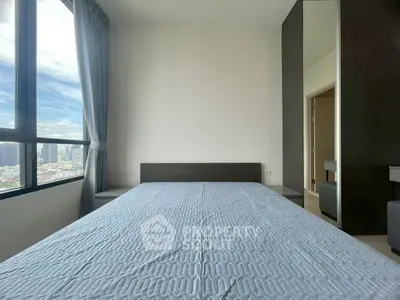 Modern bedroom with large window and city view, featuring sleek design and natural light.