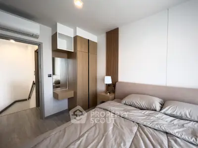 Modern bedroom with sleek design and cozy bedding in a stylish apartment.