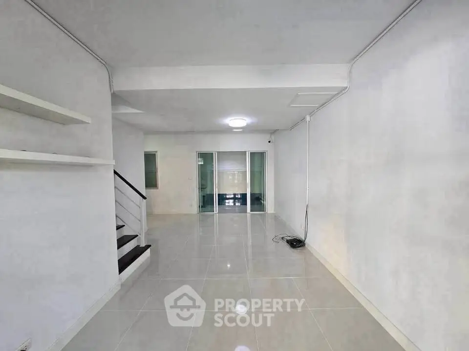 Spacious modern living room with sleek tile flooring and minimalist design, perfect for contemporary living.