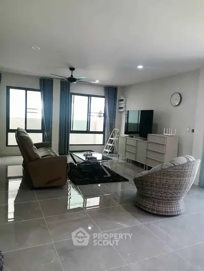 Spacious modern living room with sleek furniture and large windows for natural light.