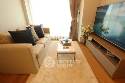 Cozy living room with modern sofa and large TV, perfect for relaxation.