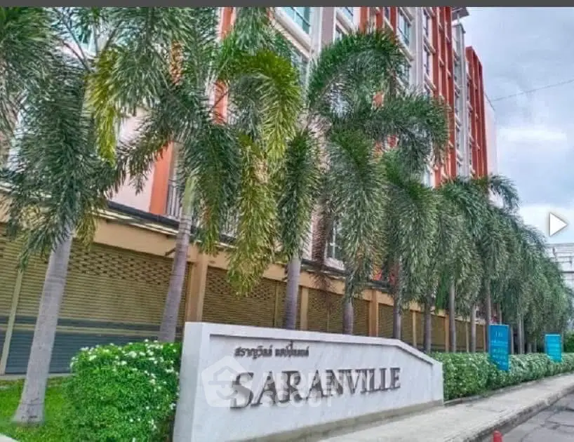 Modern building exterior with lush palm trees and prominent Saranville signage.
