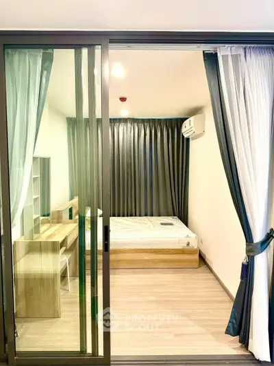 Modern bedroom with sliding glass doors and stylish furnishings in a bright apartment.