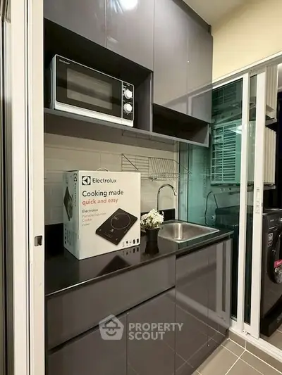 Modern kitchen with sleek cabinets and built-in microwave, featuring Electrolux appliance box.
