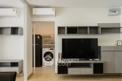 Modern living room with sleek TV unit and adjacent laundry area