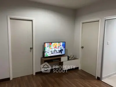 Modern living room with mounted TV and sleek wooden flooring