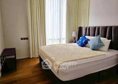 Cozy bedroom with elegant decor and natural light, featuring a plush bed and stylish curtains.