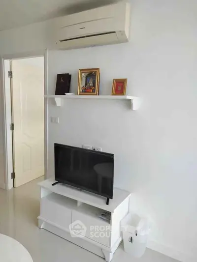 Modern living room with sleek white furniture and wall-mounted air conditioner, perfect for cozy relaxation.
