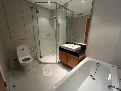 Modern bathroom with glass shower and bathtub in luxury apartment