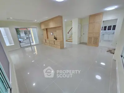 Spacious modern living room with sleek tile flooring and built-in wooden cabinetry