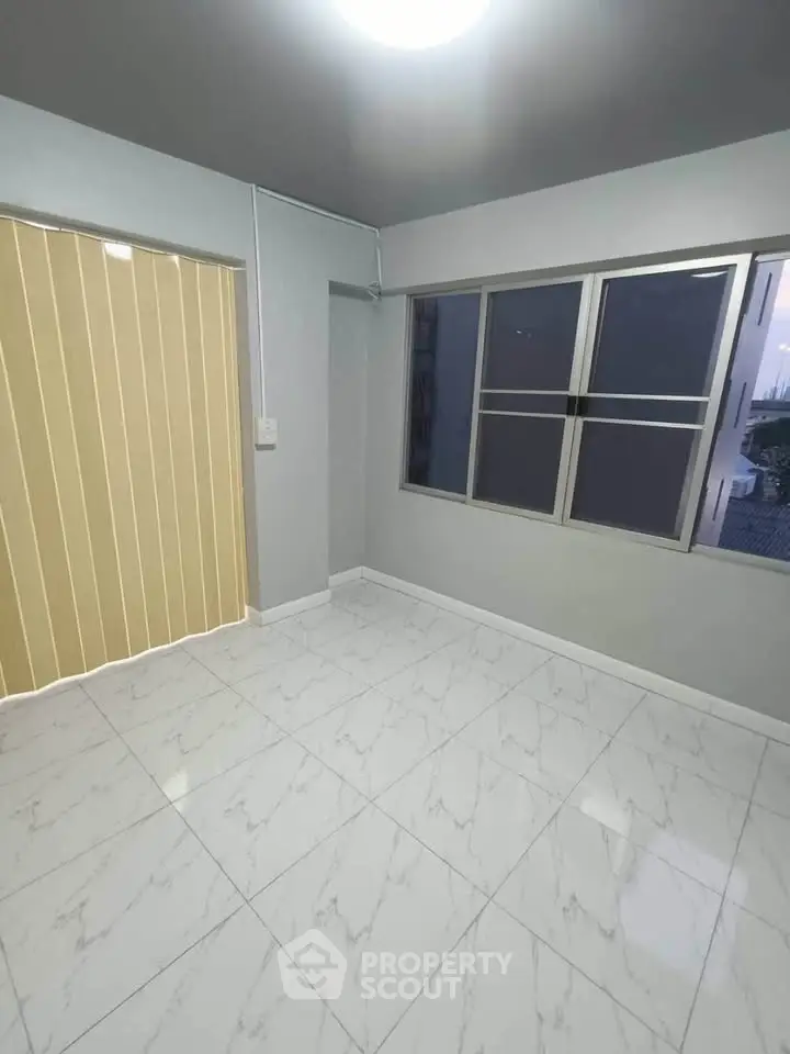 Bright empty room with large windows and glossy white tile flooring
