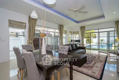 Spacious living room with elegant dining area and pool view, perfect for entertaining guests.