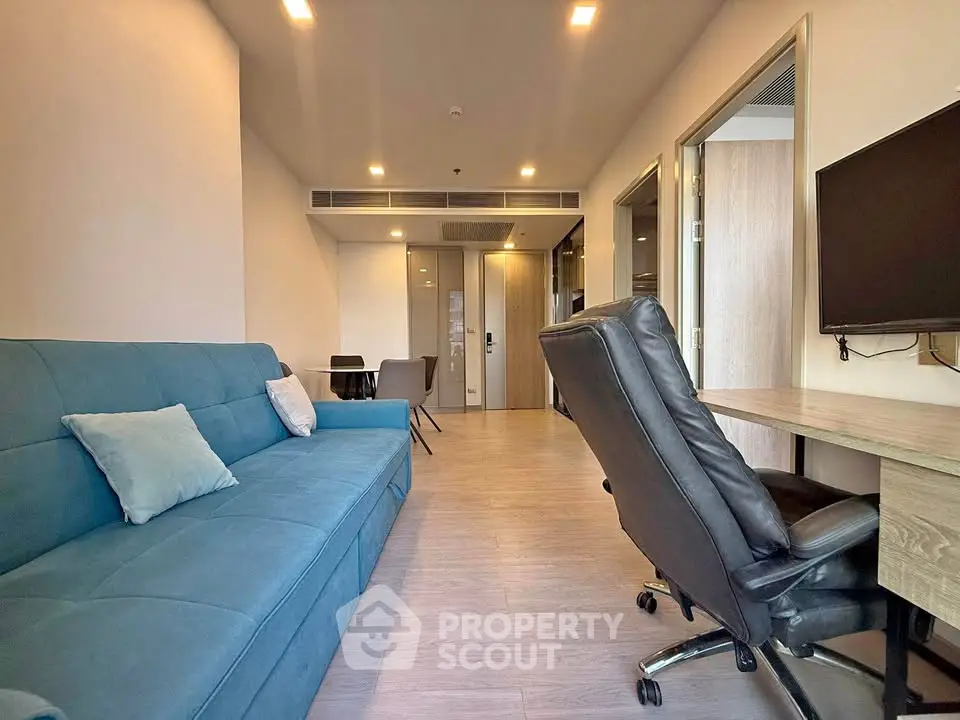Modern living room with blue sofa and office chair in stylish apartment
