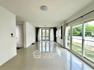 Spacious living room with large windows and garden view