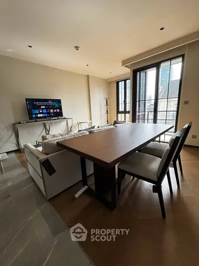 Spacious living room with modern furniture and large windows offering city views.