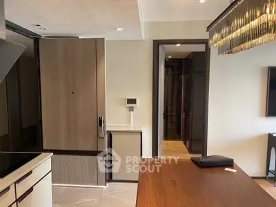 Modern kitchen with sleek design and wooden accents, featuring a closed layout and contemporary lighting.