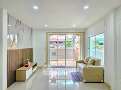 Bright and modern living room with large windows and balcony access.