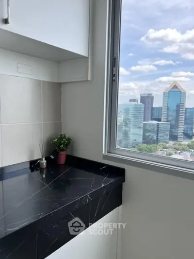 Modern kitchen with black marble countertop and city view from window