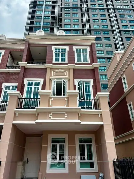 Elegant multi-story townhouse with classic brick facade and modern windows, nestled in urban setting.