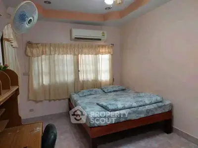 Cozy bedroom with air conditioning and natural light, perfect for relaxation.