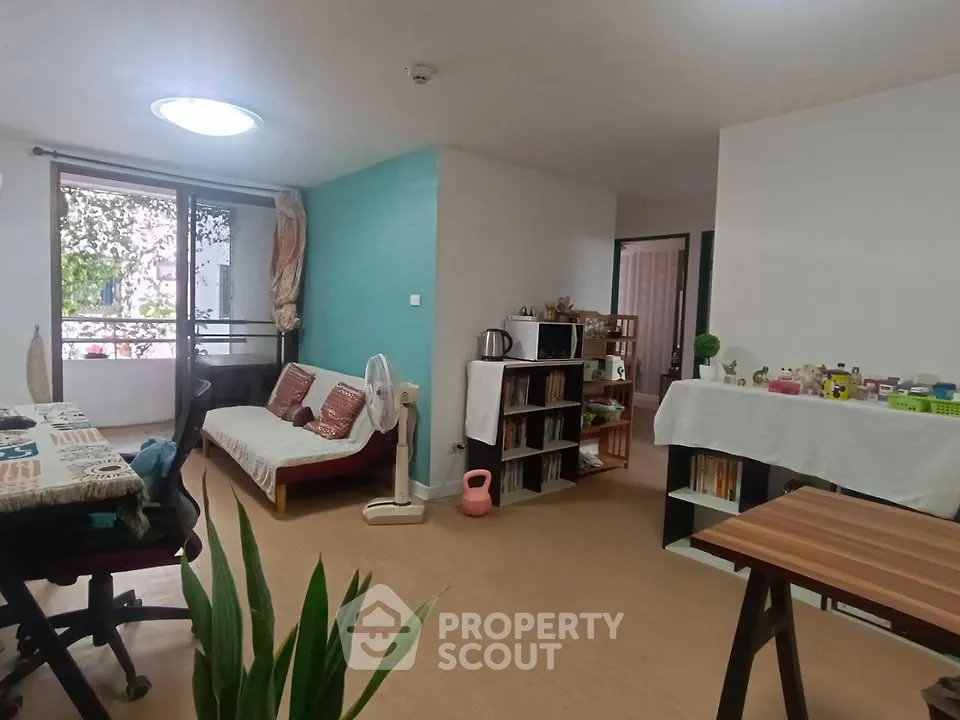 Cozy living room with natural light and balcony access, featuring modern decor and open layout.