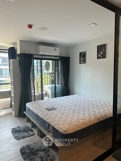 Modern bedroom with large window, stylish decor, and ample natural light in a contemporary apartment.