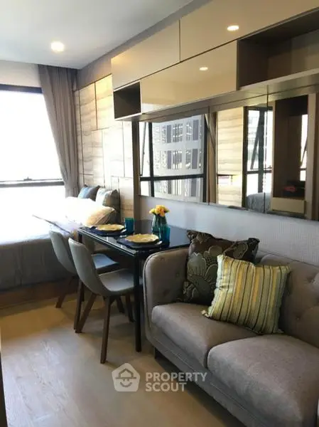 Modern living room with dining area and large windows in a stylish apartment.