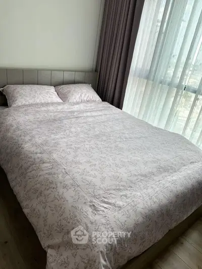 Cozy bedroom with large window and elegant curtains, perfect for relaxation.