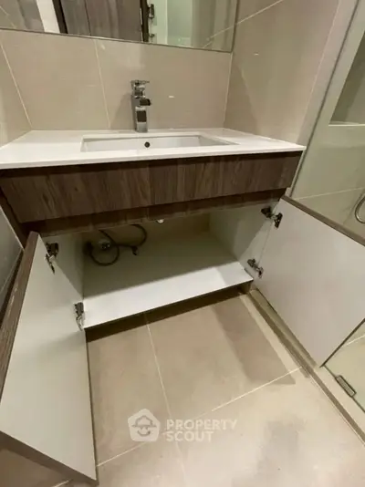 Modern bathroom vanity with open cabinet doors showcasing storage space.