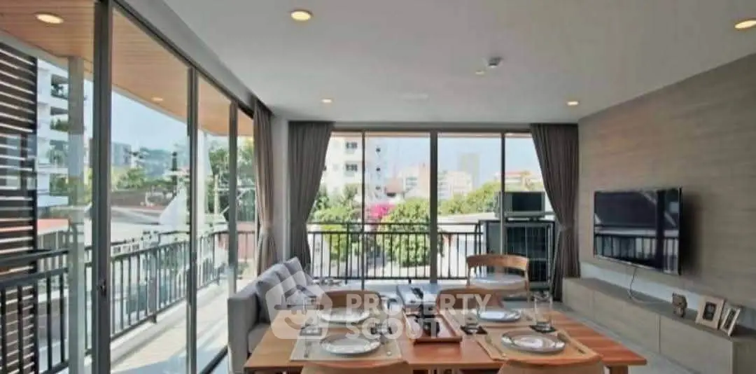 Spacious modern living room with large windows and balcony view, perfect for entertaining.