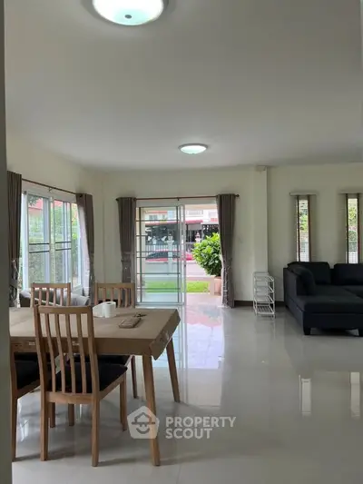Spacious living room with dining area and garden view, perfect for family gatherings.