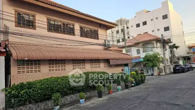 Charming residential building with lush greenery and traditional architecture in a serene neighborhood.