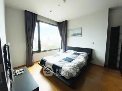 Modern bedroom with large window and stylish decor in urban apartment