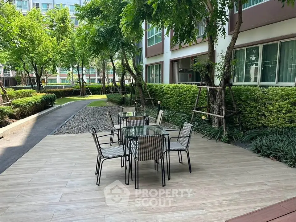 Charming outdoor garden area with seating in modern residential complex