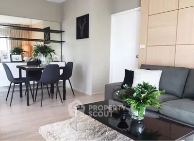 Modern living room with stylish decor and dining area, featuring sleek furniture and elegant design.